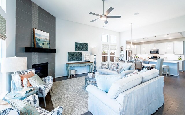 2409 Seaglass Terrace Dr, Katy, TX 77493 - living room with dark wood-style flooring, ceiling fan, a tile fireplace, a chandelier, and recessed lighting