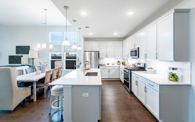 2409 Seaglass Terrace Dr, Katy, TX 77493 - kitchen featuring appliances with stainless steel finishes, a sink, a kitchen bar, dark wood-style floors, and recessed lighting