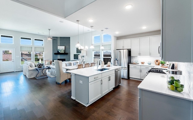 kitchen with a sink, appliances with stainless steel finishes, dark wood-style flooring, and light countertops