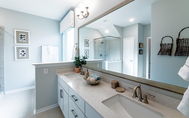full bathroom with double vanity, a stall shower, baseboards, and a sink