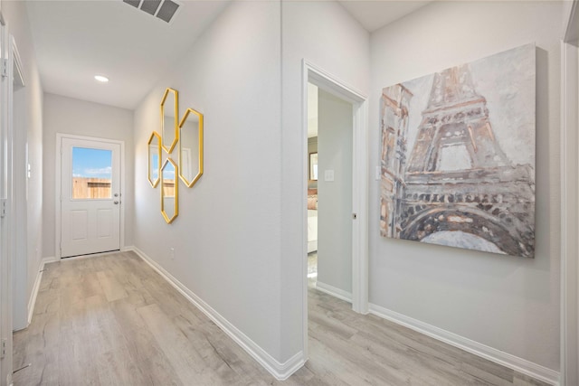 hall with light wood finished floors, visible vents, recessed lighting, and baseboards