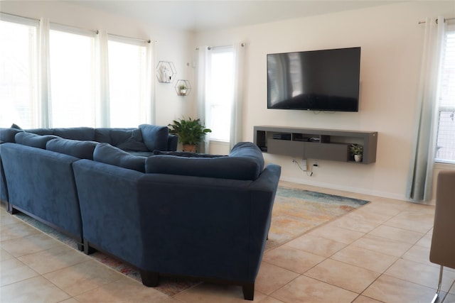 living room featuring light tile patterned floors, baseboards, and plenty of natural light