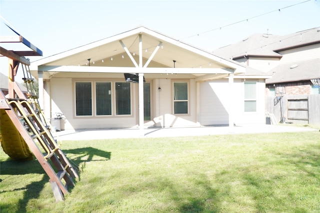 back of property with a lawn, a patio, and fence