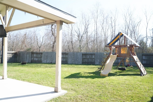 view of playground featuring a lawn and a fenced backyard