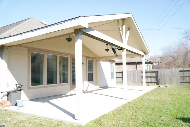 back of house featuring a patio area, a lawn, and fence