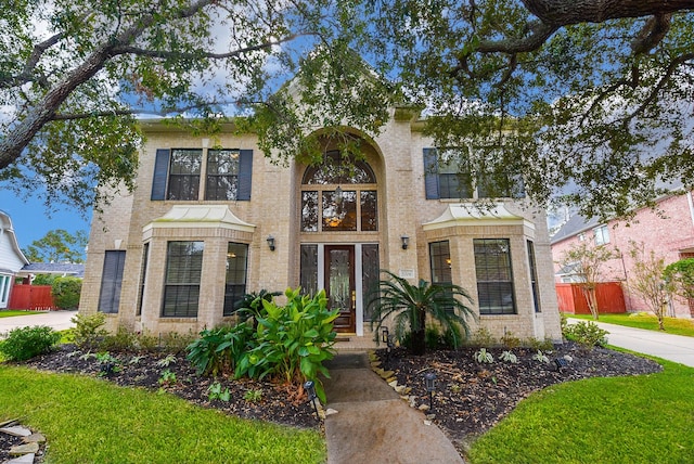 view of front facade with fence and brick siding