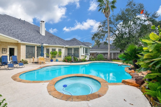 outdoor pool featuring a patio, an in ground hot tub, and fence