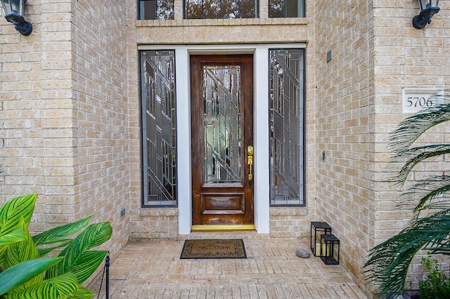 doorway to property featuring brick siding