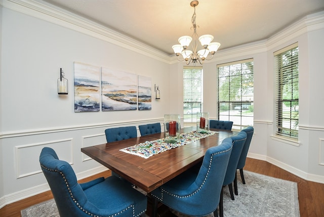 dining space featuring an inviting chandelier, wood finished floors, wainscoting, and ornamental molding