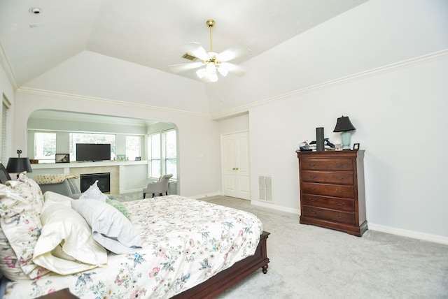 bedroom featuring visible vents, arched walkways, lofted ceiling, and carpet flooring