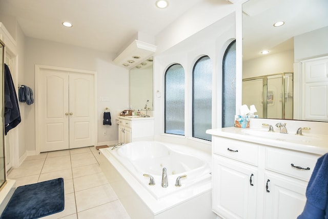 bathroom with a sink, a jetted tub, a shower stall, and tile patterned floors