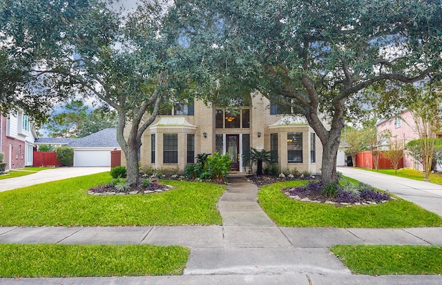 view of front of house featuring brick siding, concrete driveway, and fence