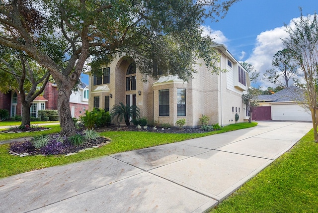 view of front of property with a garage, brick siding, and a front yard