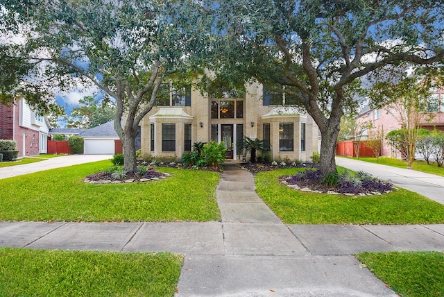 view of front of home featuring concrete driveway, fence, and a front lawn