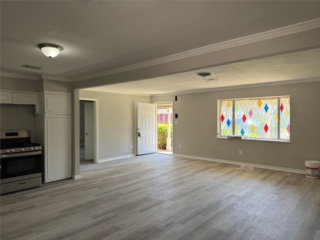 interior space featuring light wood finished floors, visible vents, crown molding, and baseboards