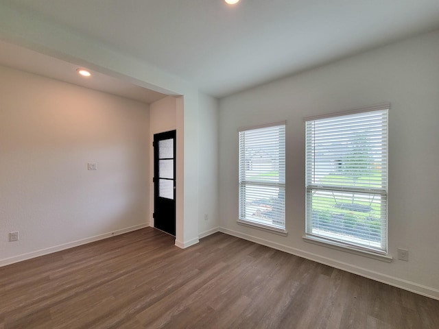 spare room with dark wood finished floors, recessed lighting, and baseboards