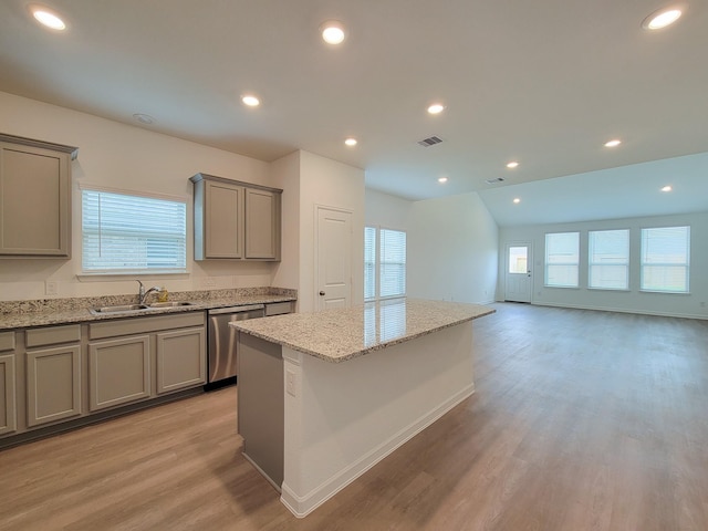 kitchen with gray cabinetry, a sink, a center island, light wood-style floors, and dishwasher