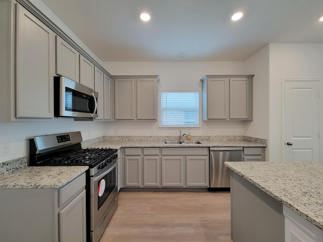 kitchen with recessed lighting, appliances with stainless steel finishes, gray cabinetry, and a sink