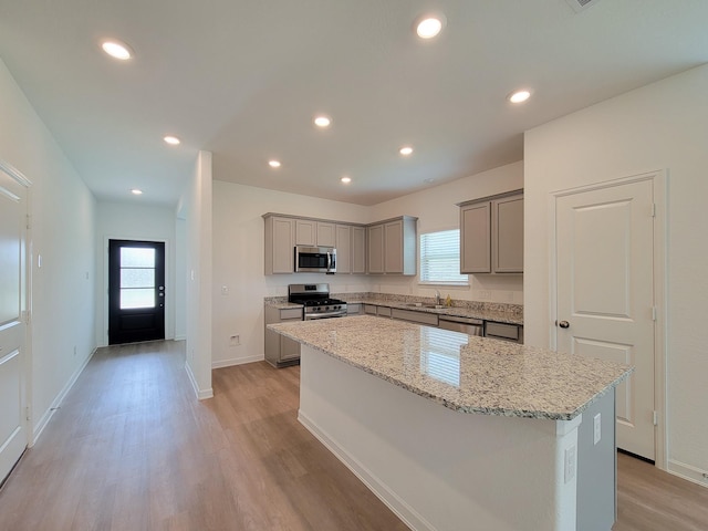 kitchen featuring a wealth of natural light, gray cabinets, appliances with stainless steel finishes, and a center island