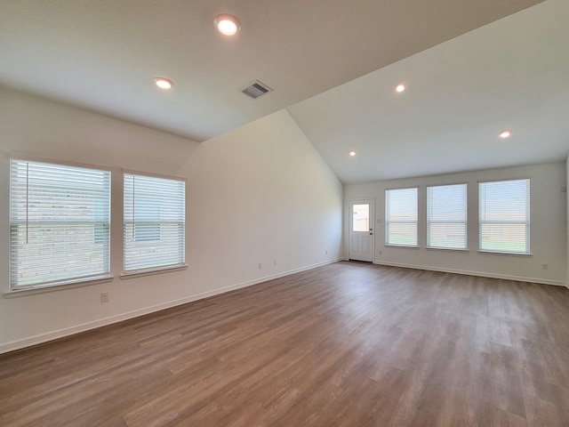 unfurnished room featuring recessed lighting, baseboards, lofted ceiling, and wood finished floors