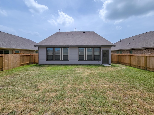 back of house featuring a lawn and a fenced backyard