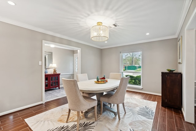 dining area with wood finish floors, visible vents, baseboards, and crown molding