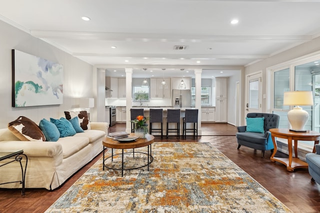 living room with crown molding, recessed lighting, visible vents, and ornate columns