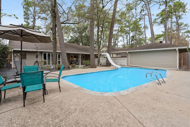 pool with fence, a water slide, and a patio area