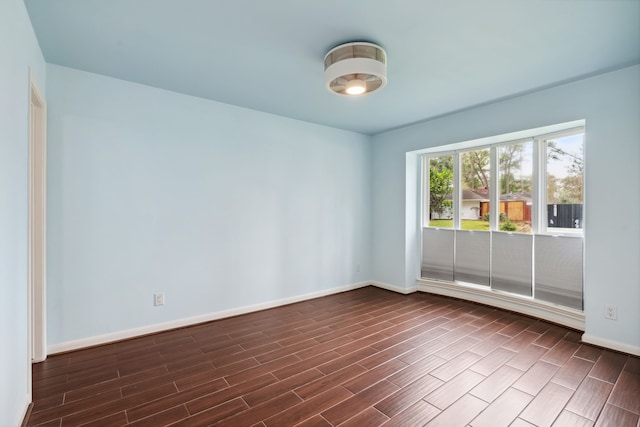 empty room with baseboards and wood tiled floor