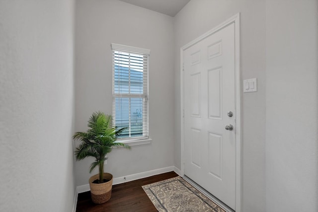 doorway with dark wood-style floors and baseboards