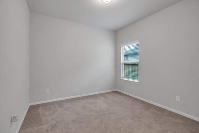 spare room featuring baseboards and carpet