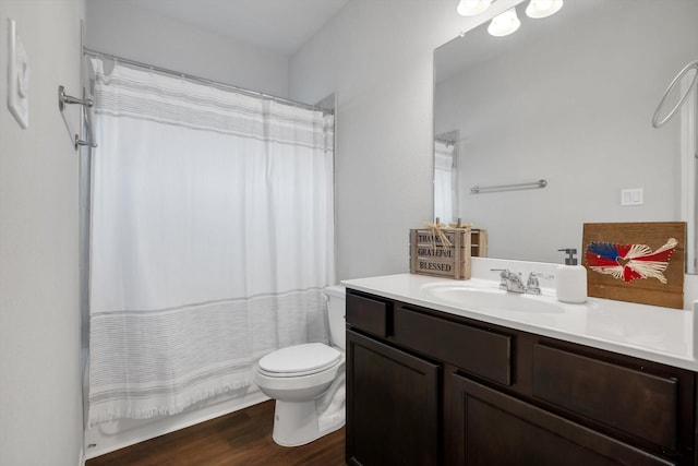 bathroom featuring toilet, wood finished floors, and vanity