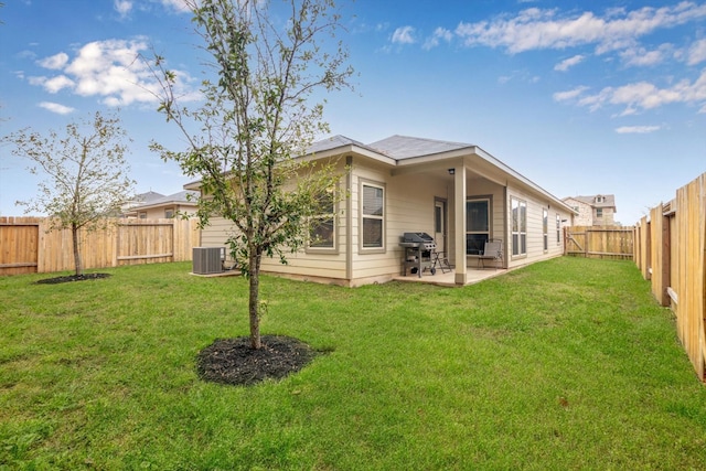 back of property featuring a yard, central AC unit, a fenced backyard, and a patio area