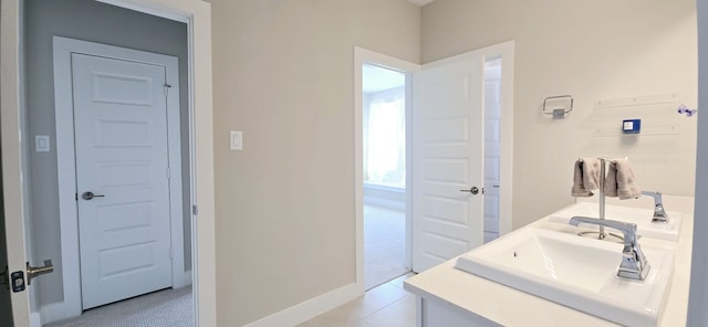 bathroom with tile patterned floors, baseboards, and a sink