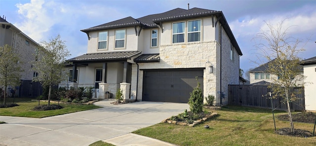 view of front of property featuring driveway, a standing seam roof, stone siding, fence, and metal roof