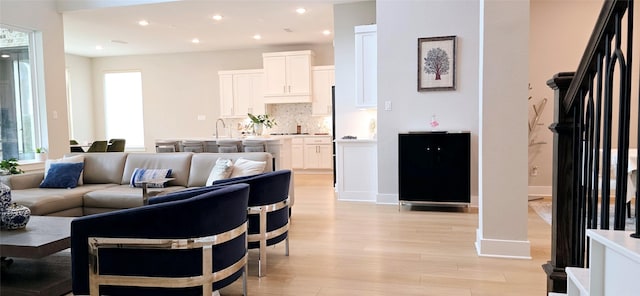 living area with recessed lighting, baseboards, a healthy amount of sunlight, and light wood finished floors