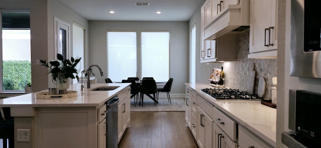 kitchen with visible vents, backsplash, black dishwasher, stainless steel gas stovetop, and a sink