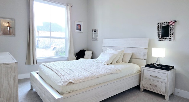 bedroom with baseboards and light carpet