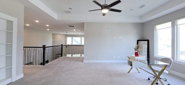 office featuring visible vents, a tray ceiling, carpet, and baseboards