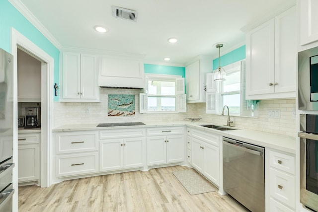 kitchen with visible vents, a sink, white cabinetry, stainless steel appliances, and light countertops