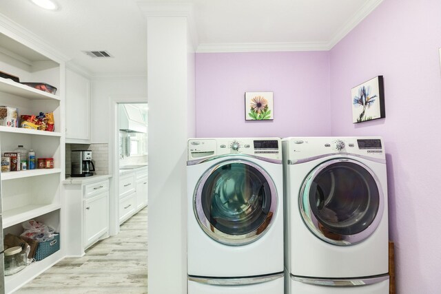 clothes washing area featuring crown molding, light wood-style flooring, visible vents, and washer and clothes dryer