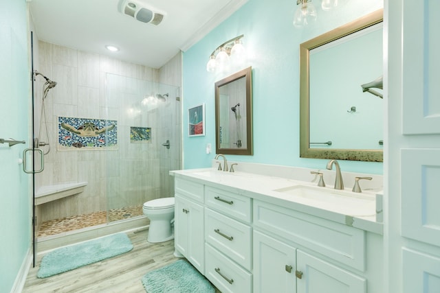 full bath featuring a shower stall, toilet, wood finished floors, and a sink