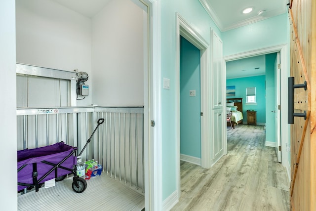 hallway with baseboards, wood finished floors, and ornamental molding