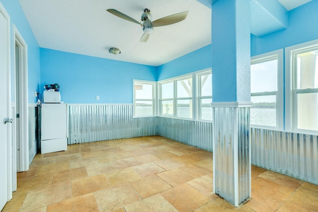 unfurnished sunroom featuring a ceiling fan