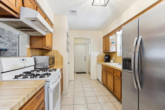 kitchen featuring under cabinet range hood, visible vents, stainless steel appliances, and light countertops