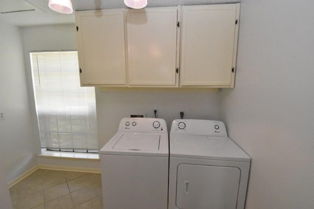 clothes washing area with cabinet space, separate washer and dryer, tile patterned floors, and a healthy amount of sunlight