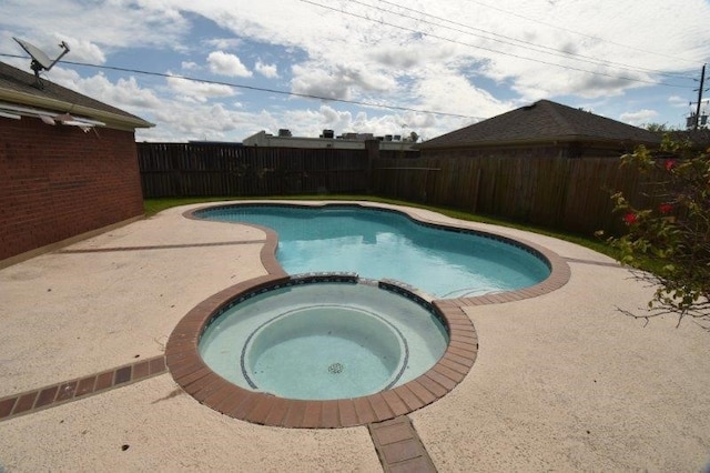 view of pool featuring a patio, a pool with connected hot tub, and a fenced backyard