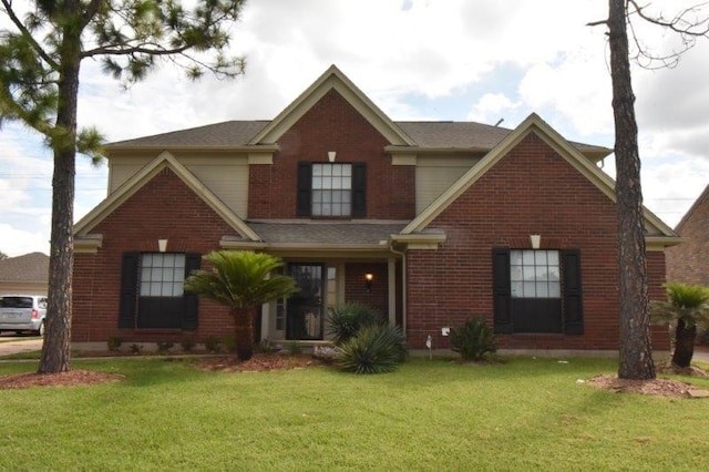 view of front of house with a front yard and brick siding