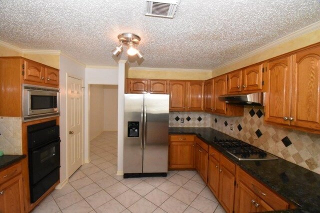 kitchen featuring under cabinet range hood, brown cabinets, and stainless steel appliances