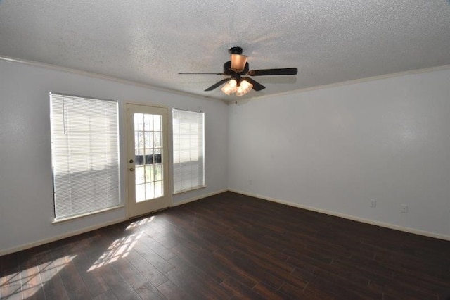 empty room with ornamental molding, a textured ceiling, baseboards, and wood finished floors